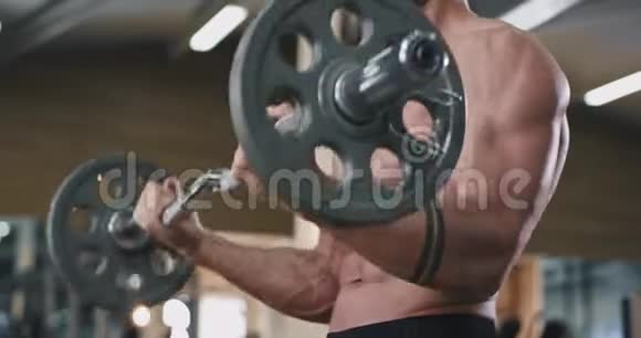 在镜头前一个健美男子锻炼身体的细节他集中工作的二头肌重量视频的预览图