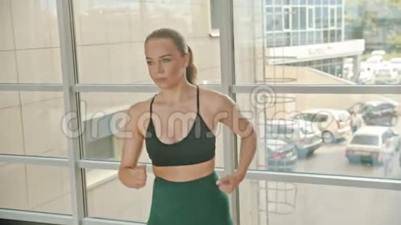 一名运动女拳击手站在窗边练拳视频的预览图