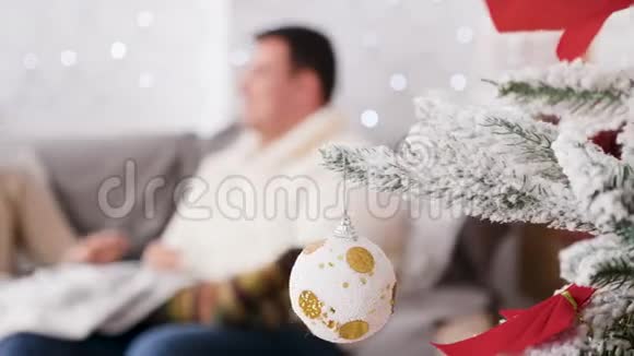 在圣诞节装饰的房间里一对相爱的夫妇坐在沙发上视频的预览图
