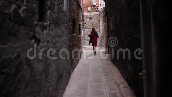 免费女游客手拿帽子在威尼斯的院子里奔跑视频的预览图