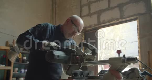 高级男主在木材厂工作压头锯切木材视频的预览图