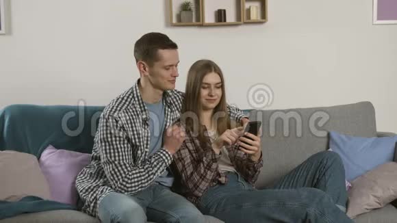 当女友使用智能手机时笑容满面的男人出现了拇指视频的预览图