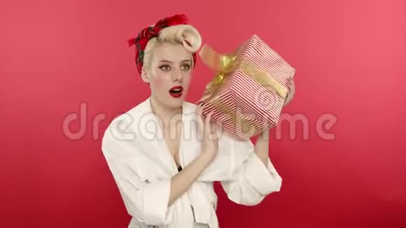 带着微笑抱着礼物盒的好奇女人视频的预览图