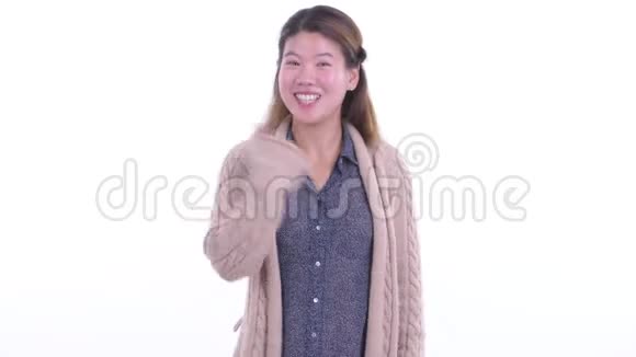 快乐的年轻亚洲女人竖起大拇指准备过冬视频的预览图