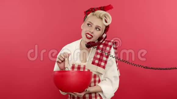 把金发女人用微笑在电话里做饭和说话视频的预览图