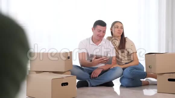 一对夫妇坐在白地板的盒子里享受热咖啡视频的预览图