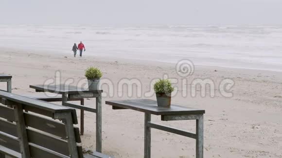 一对成熟的夫妇走过北海海滩慢动作视频的预览图