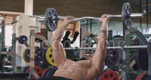 健身的年轻人在健身房锻炼举重很集中他很努力视频的预览图