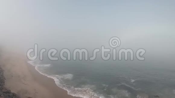 葡萄牙的女人看着地平线和海洋葡萄牙帕沃瓦兹姆空滩秋日雾蒙蒙视频的预览图