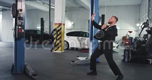 现代服务汽车修理工在修理汽车时他在镜头前非常兴奋地跳舞视频的预览图