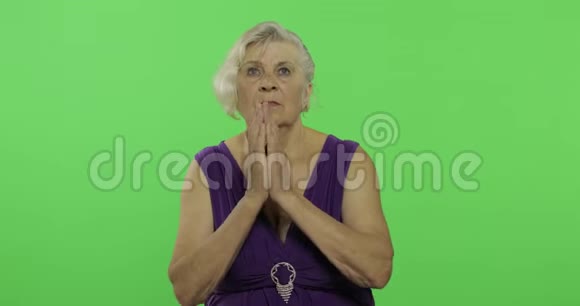 一位老妇人双手合十祈祷老奶奶彩色键视频的预览图