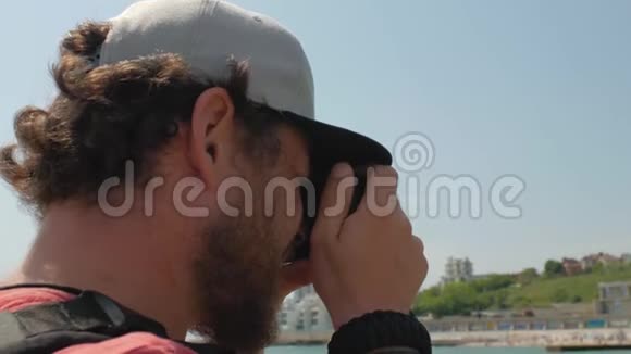 一个留着胡须戴着帽子的人从靠近大海的码头拍了一张照片4公里视频视频的预览图