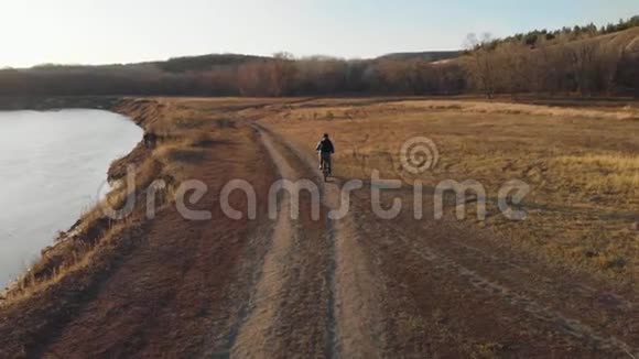 日落时骑自行车骑在山上的空中景色视频的预览图