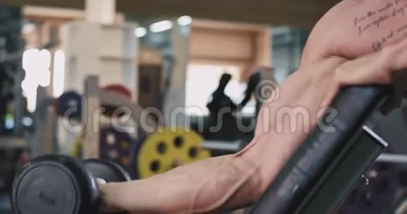 详细的健身男子在一个大的宽敞的健身房做锻炼肖像肱二头肌锻炼提升哑铃视频的预览图