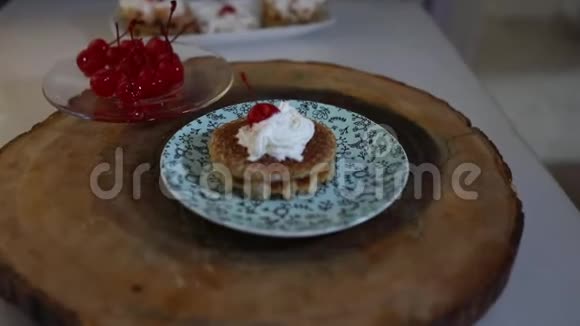 一块比利时华夫饼和饼干上面放着鲜奶油和糖中的樱桃放在盘子里越来越近越来越远视频的预览图