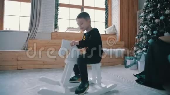 可爱的小男孩骑在玩具马上视频的预览图