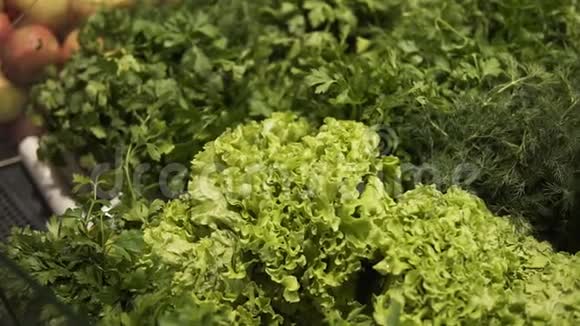 新鲜沙拉叶的剪辑片段一只雄性手从超市的柜台上拿绿色蔬菜和沙拉叶视频的预览图
