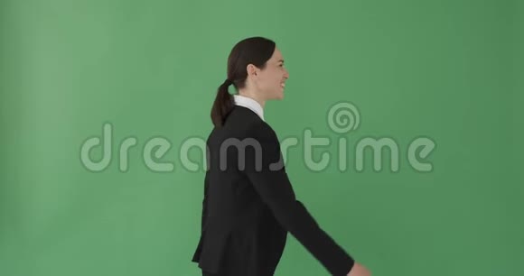 快乐的女商人走过绿色的背景视频的预览图