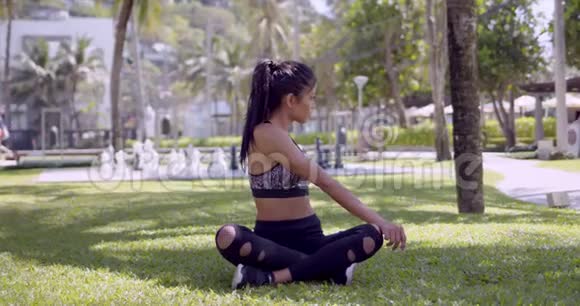 亚洲放松的女人双腿交叉坐在公园里视频的预览图