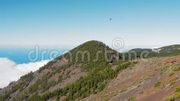 滑翔伞上方低密云和山峰和绿色森林特内里费西班牙视频的预览图