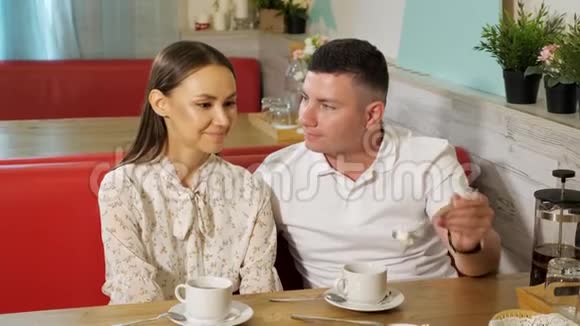 年轻人假装在餐桌上喂女朋友吃蛋糕视频的预览图