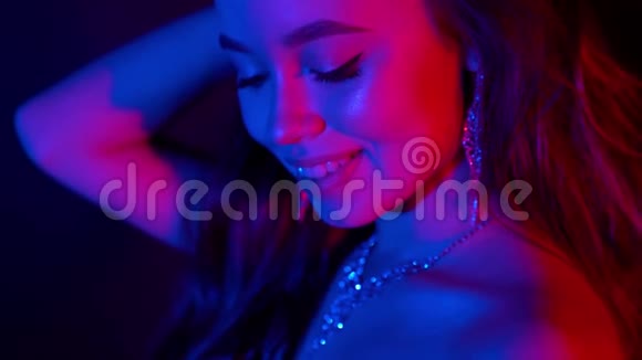 霓虹灯里美丽的女人派对她脖子上的珠宝庆祝活动视频的预览图