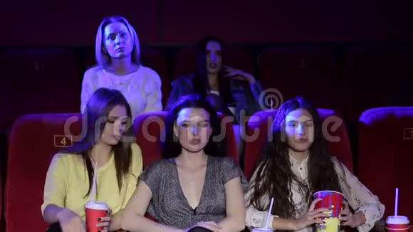 有趣的女孩朋友在电影院一起看电影和吃爆米花视频的预览图