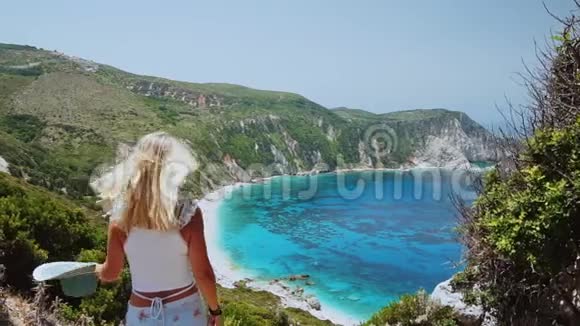在希腊的凯法洛尼亚岛美丽的金发女人在暑假举起太阳帽幸福生活视频的预览图