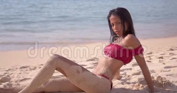 沙滩上有沙滩腿的放松女人视频的预览图