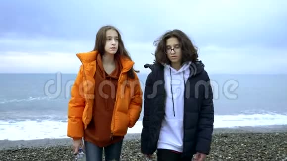 青少年在秋天把塑料垃圾扔到海滩上视频的预览图