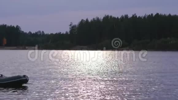 在美丽的秋天森林里一个女人在一个大湖上的橡皮船上漂浮着视频的预览图