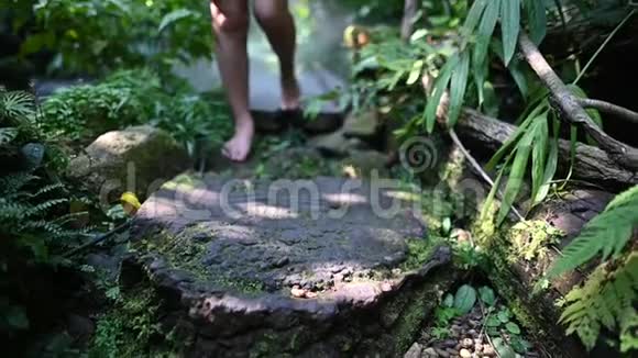 妇女在花园里散步的慢动作孤独的女孩脚没有鞋子在森林里视频的预览图