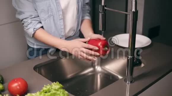 女人在厨房里洗红辣椒黄瓜和西红柿然后把它们放在盘子里自制食品概念年轻女子视频的预览图