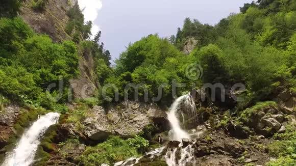 美丽的瀑布高山峰上有苔藓的岩石低角度拍摄视频的预览图