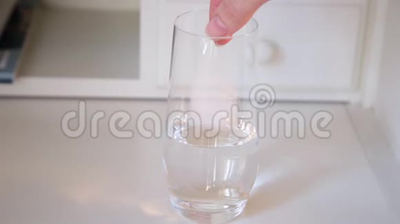 手把阿司匹林或止痛药泡腾片放入一杯水中视频的预览图