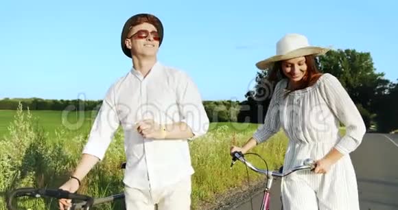 一对夫妇在田野路上骑自行车视频的预览图