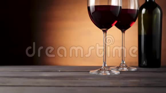 豪华红酒美味的葡萄酒由两个酒杯中的美味红葡萄在靠近瓶子的桌子上制成视频的预览图