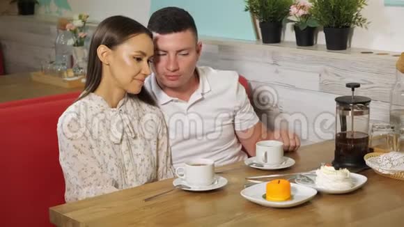 男人在咖啡馆里用茶和蛋糕亲吻女伴视频的预览图