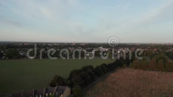 日出时飞越绿野向伦敦郊区的空中景色视频的预览图