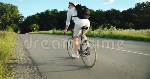 男子骑自行车在乡村的后景视频的预览图