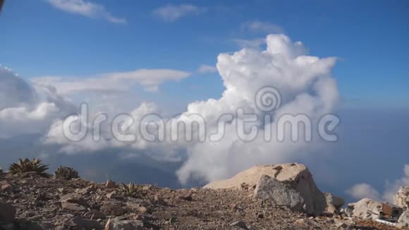 年轻的男性徒步旅行者背包伸向山顶背景多云举起手男子旅游视频的预览图