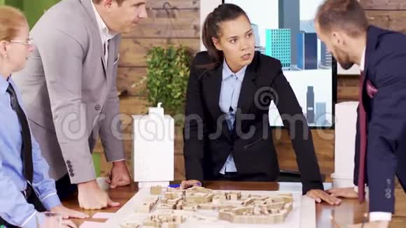 会议室里的女建筑师指着小镇视频的预览图