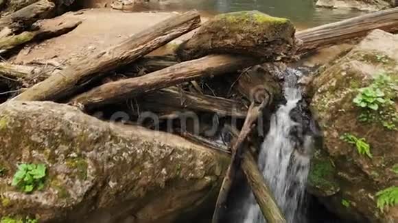 一位男性旅行者的鸟瞰图他背着背包站在雄伟瀑布前的岩石上欣赏着美丽的景色视频的预览图