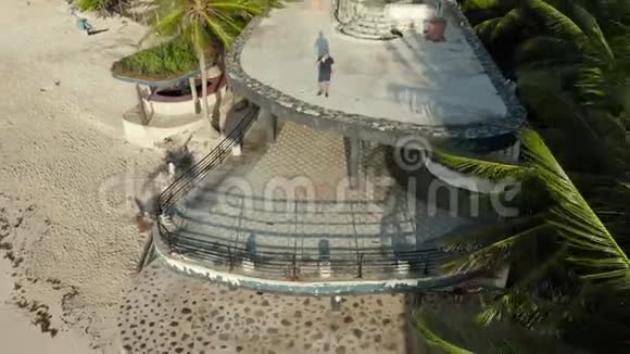 4k空中射击男子在废弃海滩餐厅屋顶喝咖啡视频的预览图