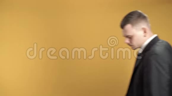 一位严肃的商人在黄色背景下交叉双臂的肖像视频的预览图