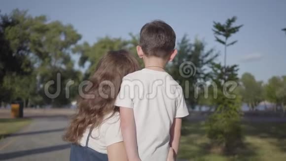 后景姐姐花时间和弟弟在夏天公园聊天户外休闲友好视频的预览图