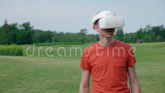 一个男人在公园里用VR耳机把头转向左边视频的预览图