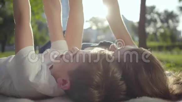 在户外姐姐和弟弟躺在毯子上那个男孩和女孩躺在公园里视频的预览图