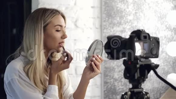 一位漂亮的化妆师在她的嘴唇上涂了唇彩视频的预览图