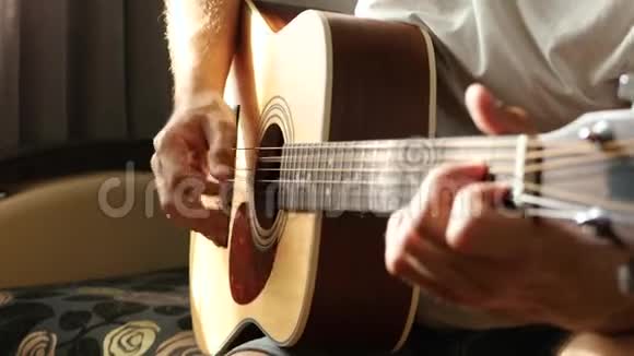 这位音乐家用黄色的原声吉他演奏快速的节奏阳光穿过手指和琴弦视频的预览图